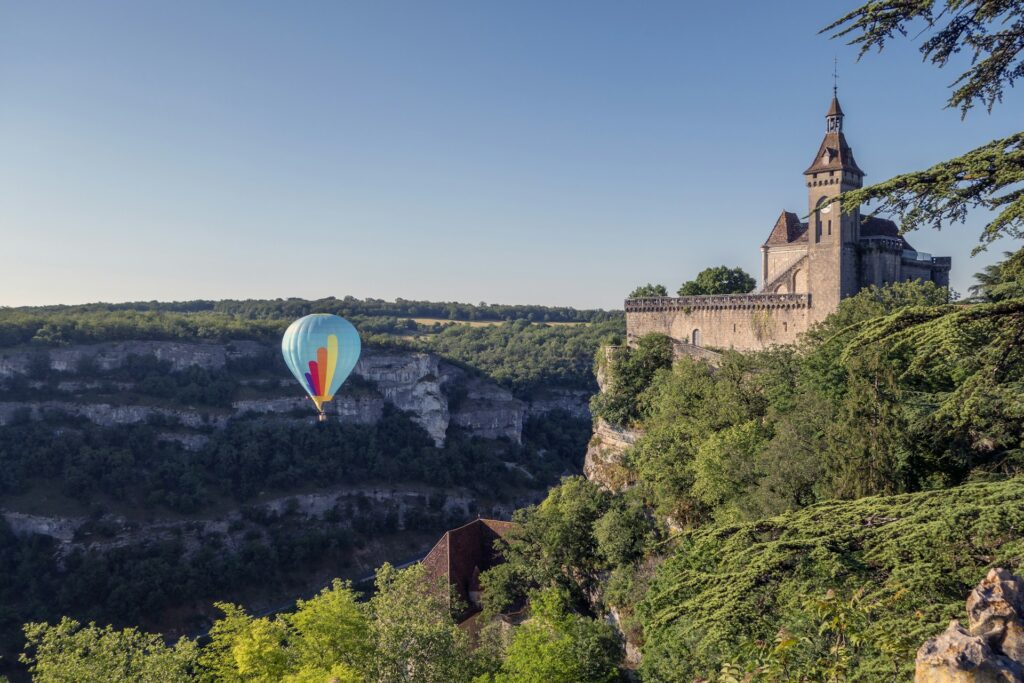 Montgolfière survolant Rocamadour et le canyon de l'Alzou au lever du soleil