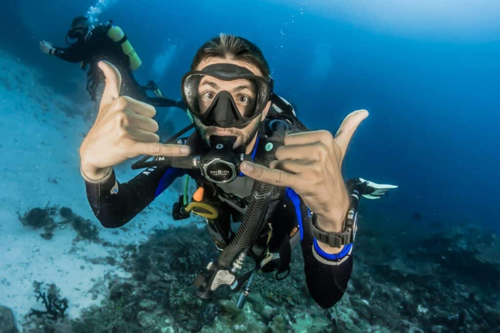 Un homme équipée d'une combinaison et d'une bouteille d'air comprimé lors d'une plongée sous-marine