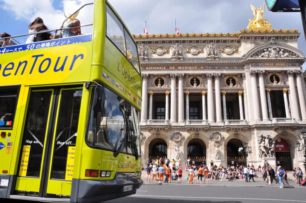 Un bus touristique à toit ouvert devant l'Opéra de Paris