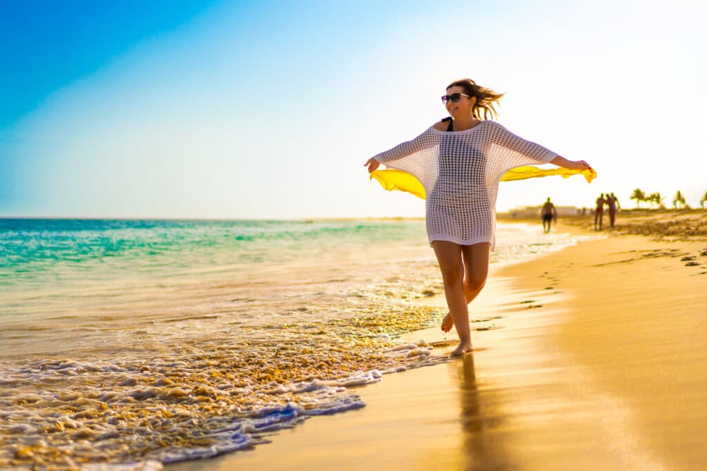Une jeune femme marche sur une plage d'île de Maio, un paradis dans l'archipel du Cap-Vert.