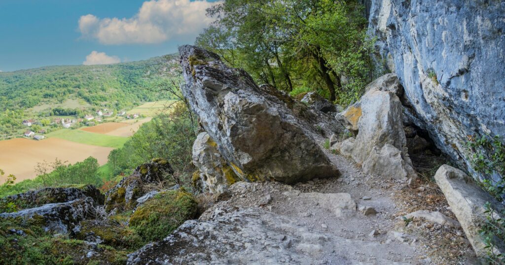 Sentier de randonnée sur les causses du Quercy avec rochers calcaires et vue sur la vallée