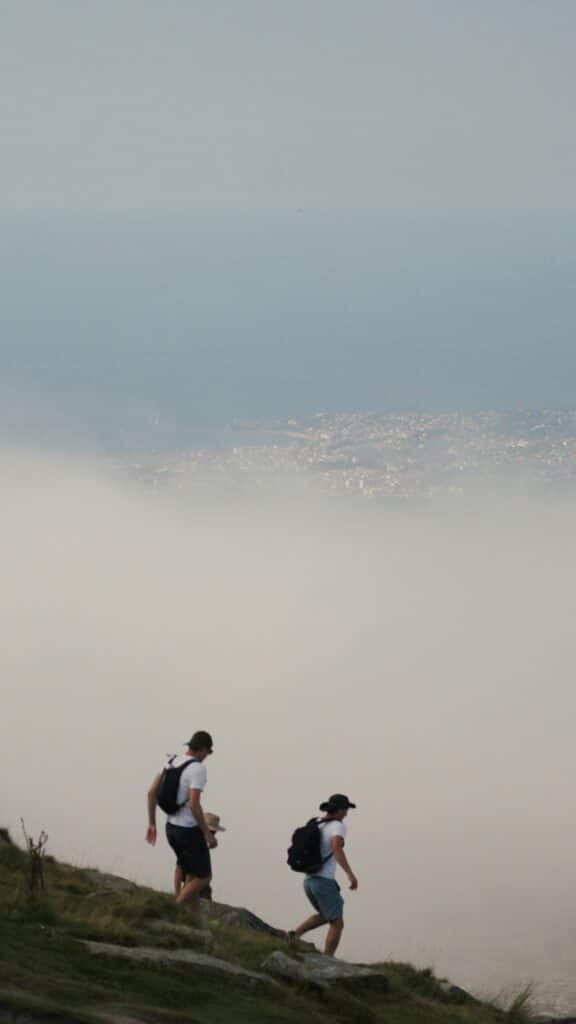 Randonneurs au sommet de la Rhune au-dessus des nuages avec vue sur la côte basque