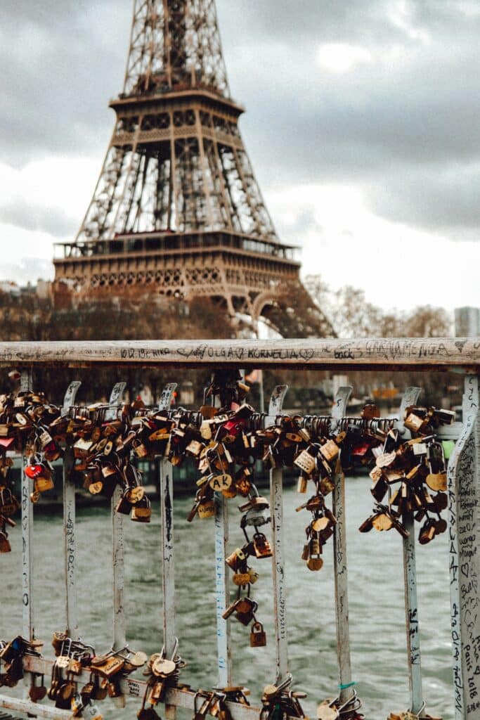 Des cadenas accrochés sur un pont qui donne sur la Tour Eiffel