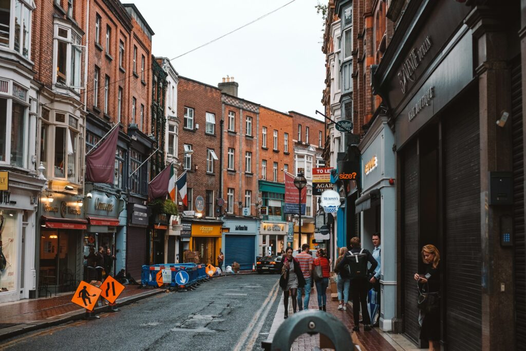 Rue animée du centre de Dublin avec drapeau irlandais et façades en brique