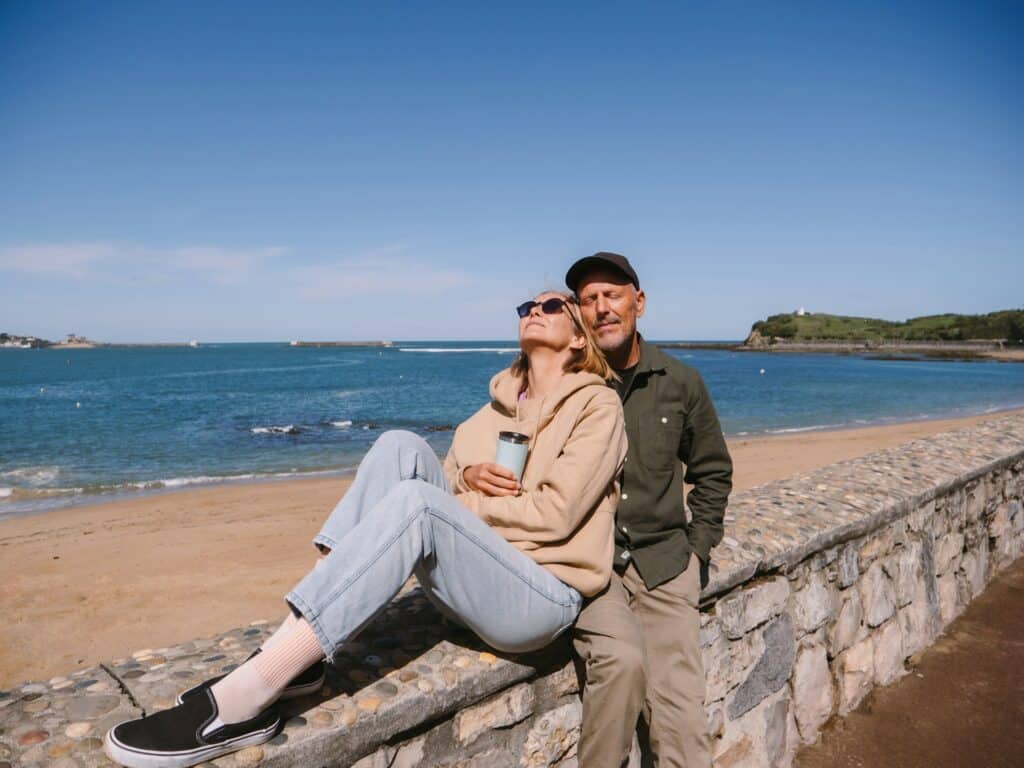 Un couple enlacé profite du soleil au bord de la plage de Saint Jean de Luz.