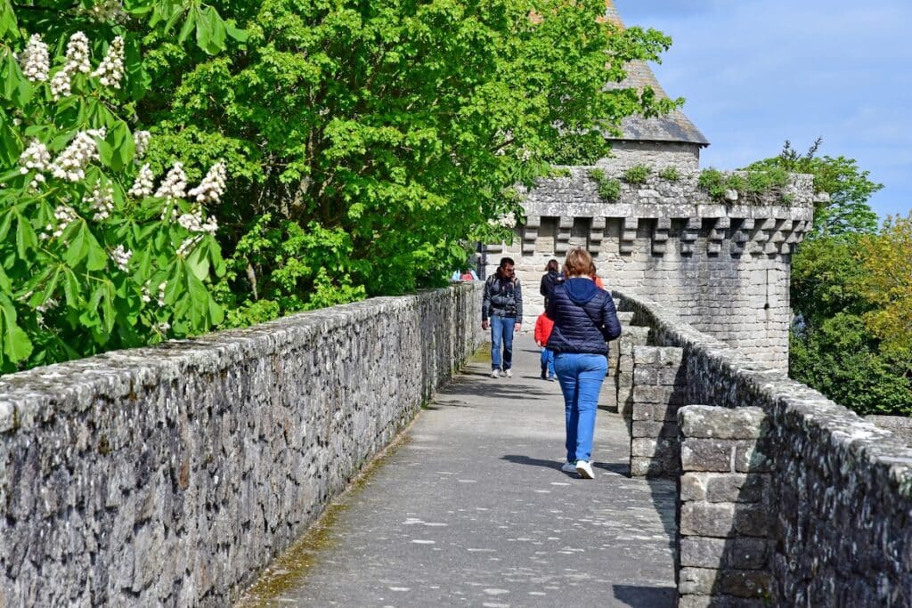 Des personnes flânent sur les remparts de Guérande au printemps.