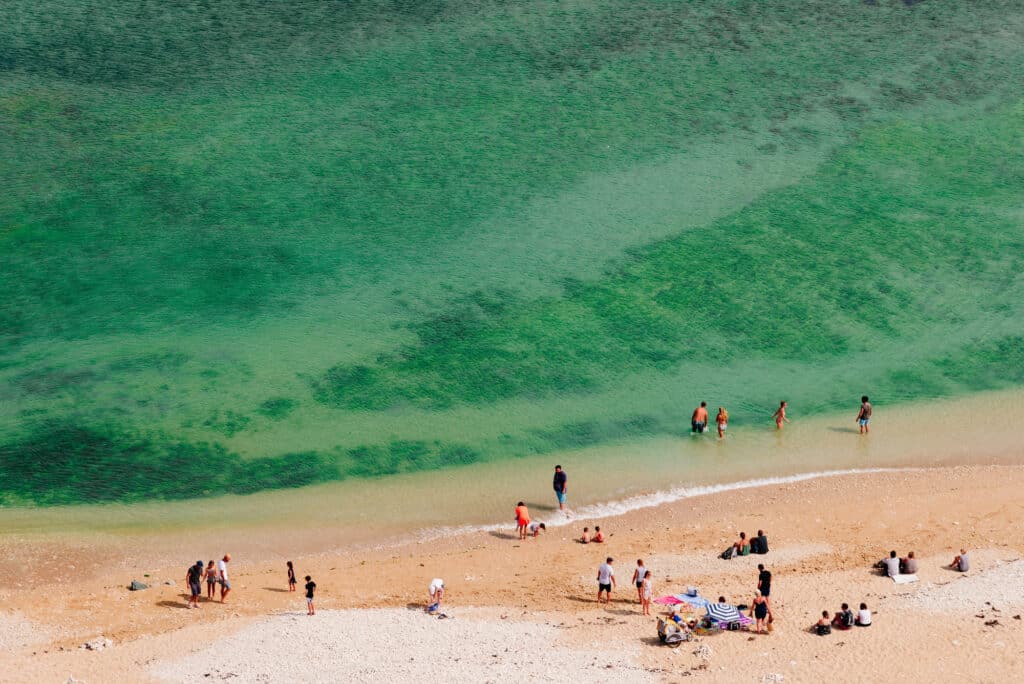 Une plage au sable dorée de l'île de Ré en été avec quelques vacanciers.