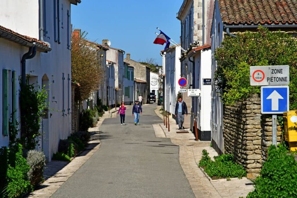 Des personnes se promènent dans une rue du village des Portes en Ré