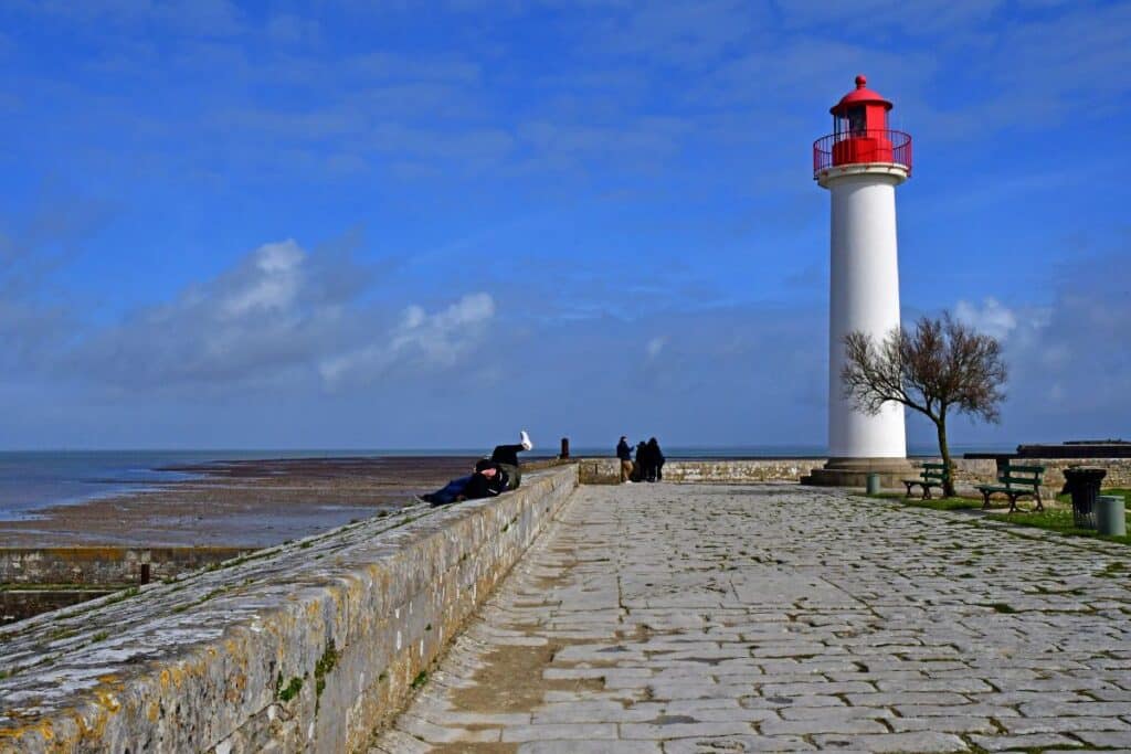 Des personnes admirent la vue sur l'océan Atlantique aux pieds du phare de Saint-Martin-en-Ré.