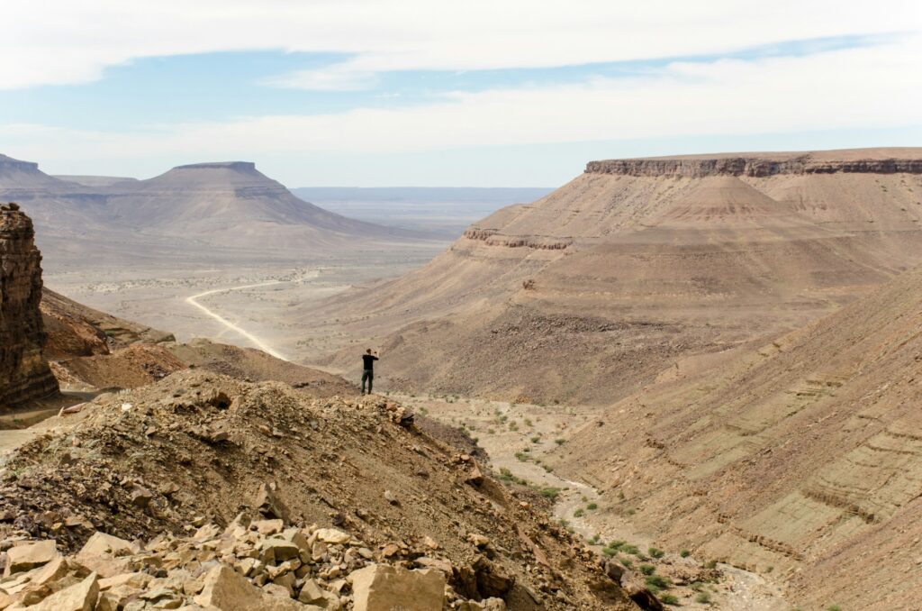 Un homme admire le paysage montagneux de l'Adrar lors d'une randonnée.