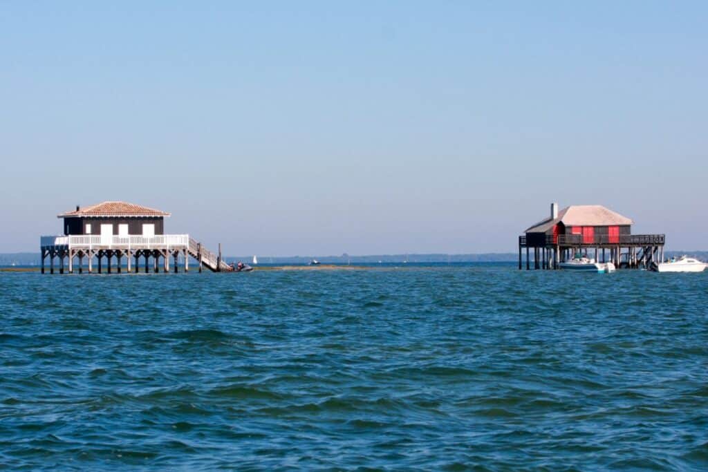 Deux cabanes tchanquées du bassin d'Arcachon à marée haute.