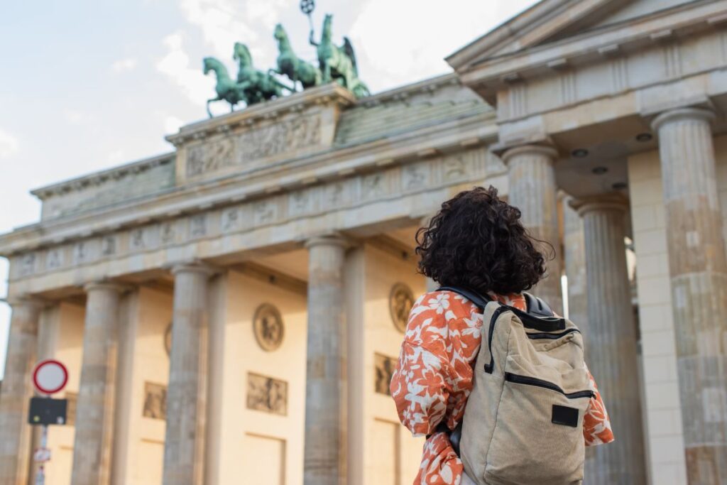 Une jeune femme admire la porte de Brandebourg à Berlin.
