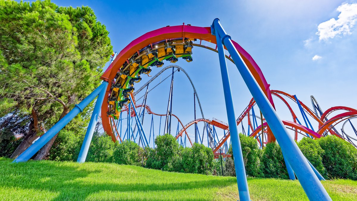 Un train de Dragon Khan dans un looping rouge, avec Shambhala en arrière-plan, à PortAventura Park