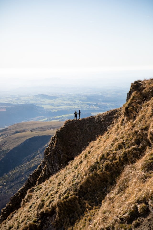 Deux randonneurs admirent la vue depuis le Poy de Sancy