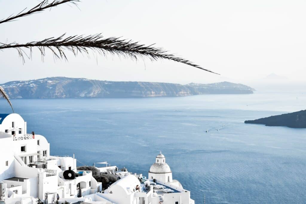 Vue panoramique sur Fira depuis la caldeira de Santorin avec la mer Égée et les îles volcaniques en arrière-plan