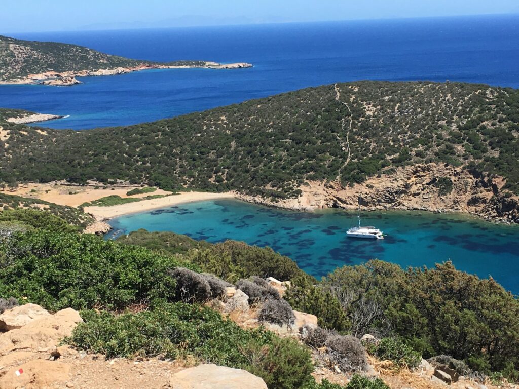 Une petite crique avec un bateau en mouillage découverte depuis un sentier de randonnée de l'île de Sfinos.