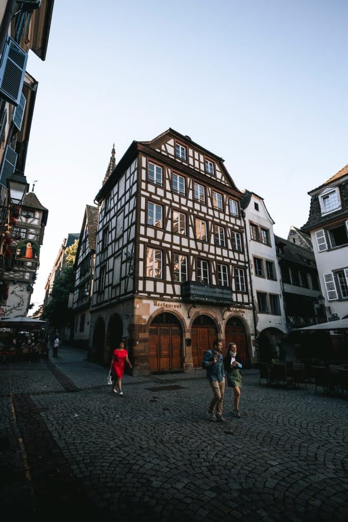 Des personnes cherchent des réponses aux énigmes d'un jeu de piste dans le quartier de la petite France à Strasbourg.