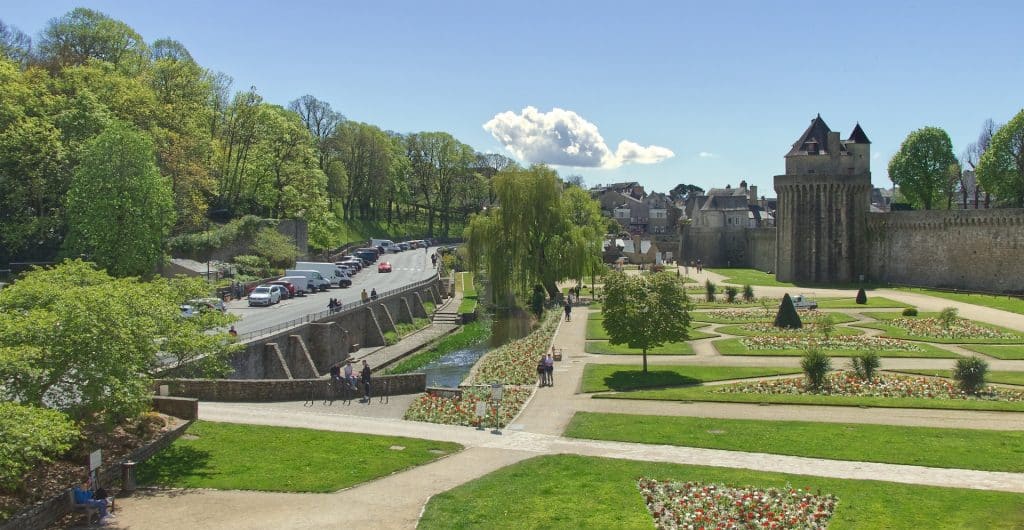 Des personnes se promènent dans le jardin des remparts de Vannes n jour d'été.