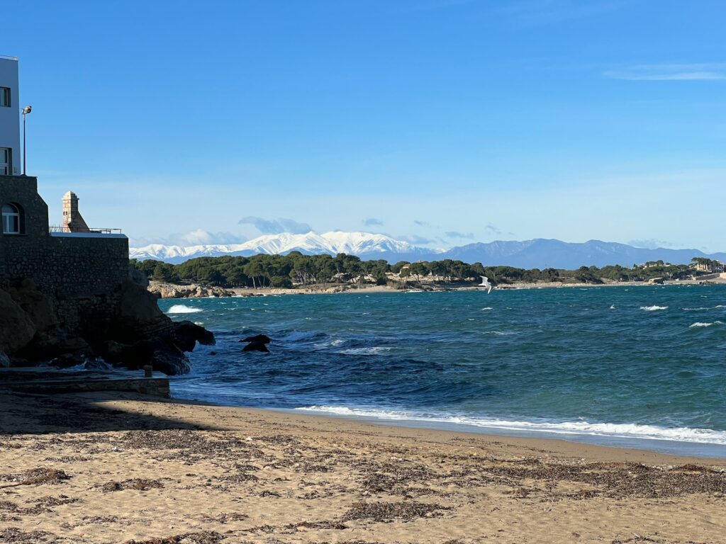 Vue sur les Pyrénées enneigés depuis une plage de la station balnéaire catalane de L'Escala.