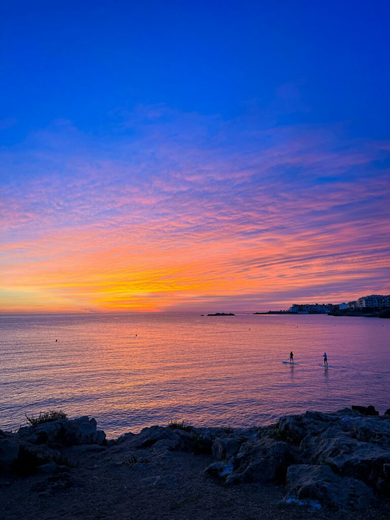Deux personnes sortent en paddle au moment du coucher de soleil dans la Baie de l'Escala.