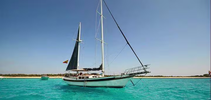 Un voilier mouille près d'une plage lors d'une excursion au départ de Lloret de Mar.