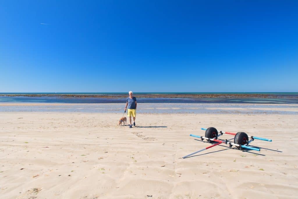 Un vieil homme et son chien sur une plage de l'île de Ré.