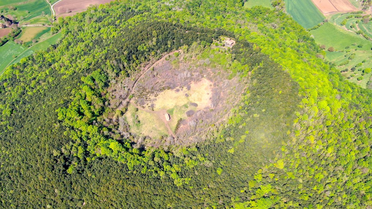 Vue aérienne du cratère boisé du volcan de Santa Margarida et de l'ermitage en son centre, dans la Garrotxa
