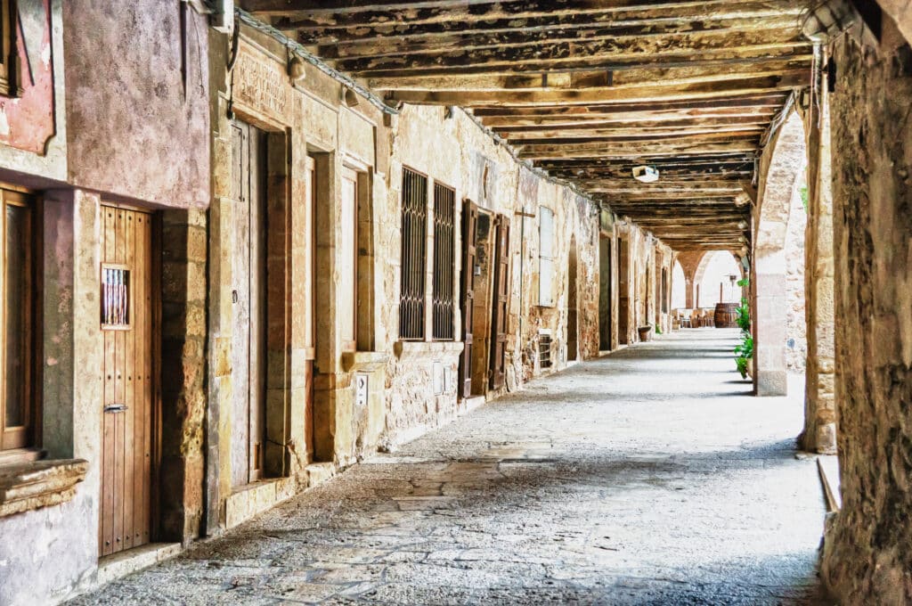 Arcades gothiques de maisons qui bordent le Firal dels Bous à Santa Pau.