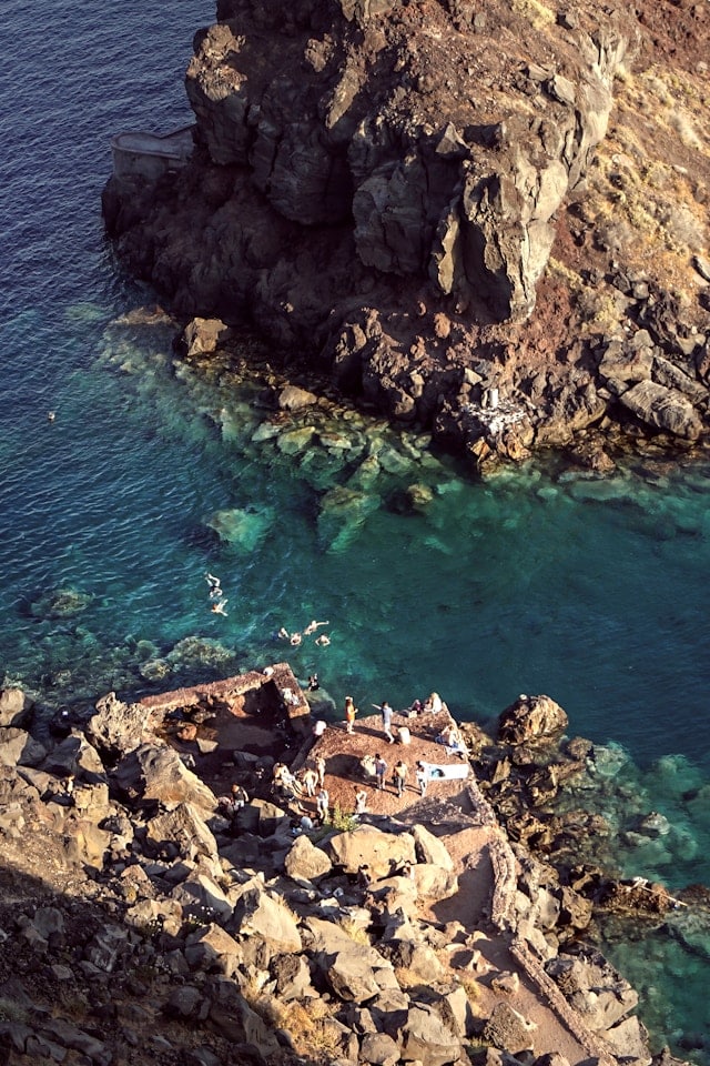 Des nageurs sur une plateforme dans la baie d'Amoudi sur l'île de Santorin.