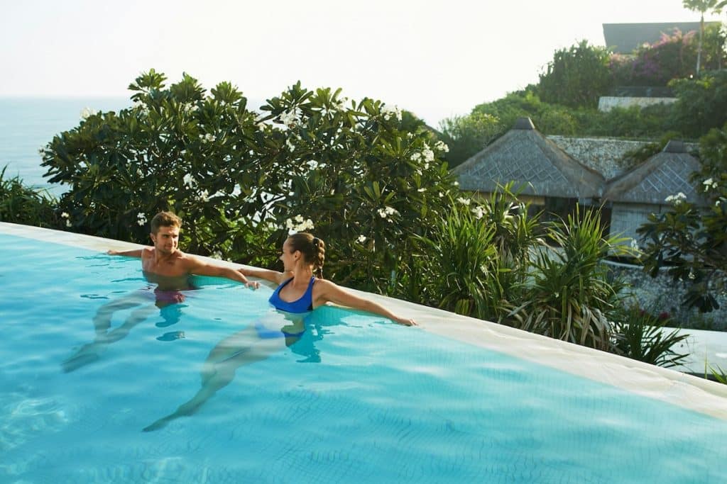 Un couple profite de la piscine d'un hôtel en Asie.