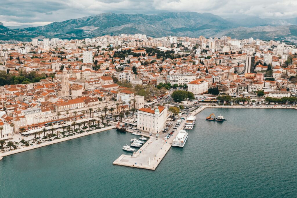 Vue aérienne de la Riva et du port de Split avec les bateaux à quai et les montagnes en arrière-plan
