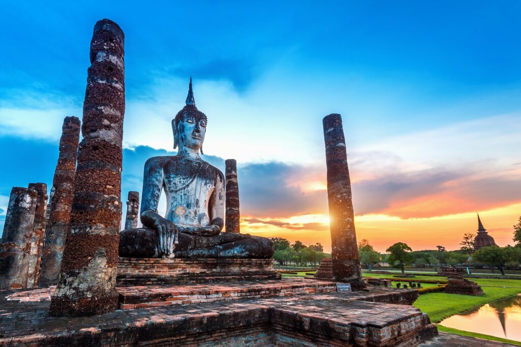 Statue de Bouddha au coucher du soleil dans le parc historique de Sukhothai en Thaïlande