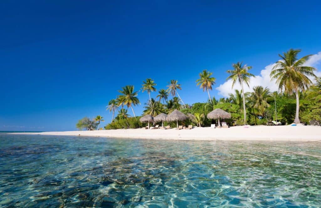 Transats et parasols sur une plage déserte de l'atoll de Tikehau