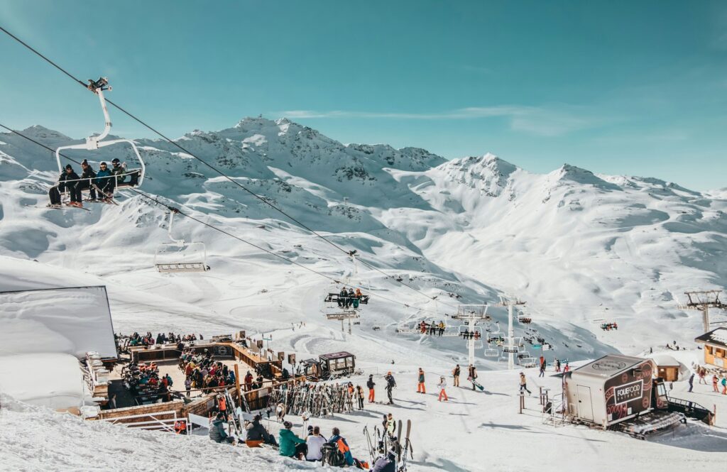 Des skieurs sur un télésiège passent au-dessus d'un restaurant d'altitude de Val Thorens.