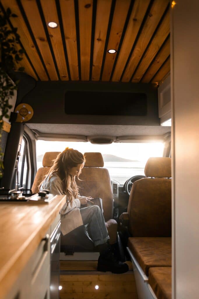 Intérieur chaleureux d'un van aménagé avec plafond en bois et kitchenette