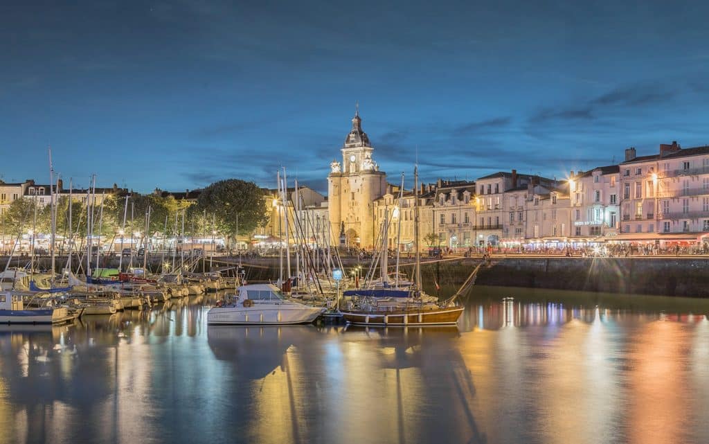 Le Vieux-Port de La Rochelle de nuit, voiliers amarrés devant la porte de la Grosse Horloge illuminée