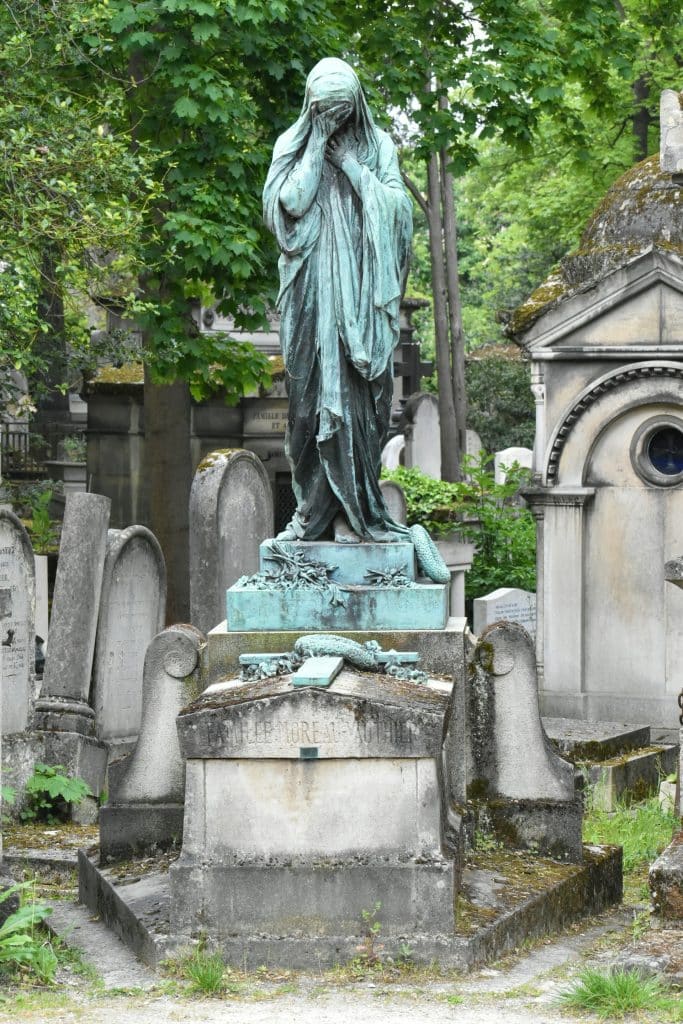 Une statue au milieu de tombes au cimetière du Père Lachaise