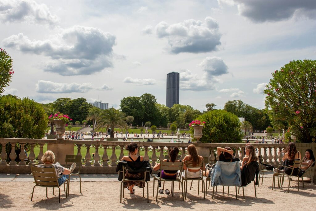 Des personnes assis sur les chaises mises à disposition bronzent au Jardin du Luxembourg