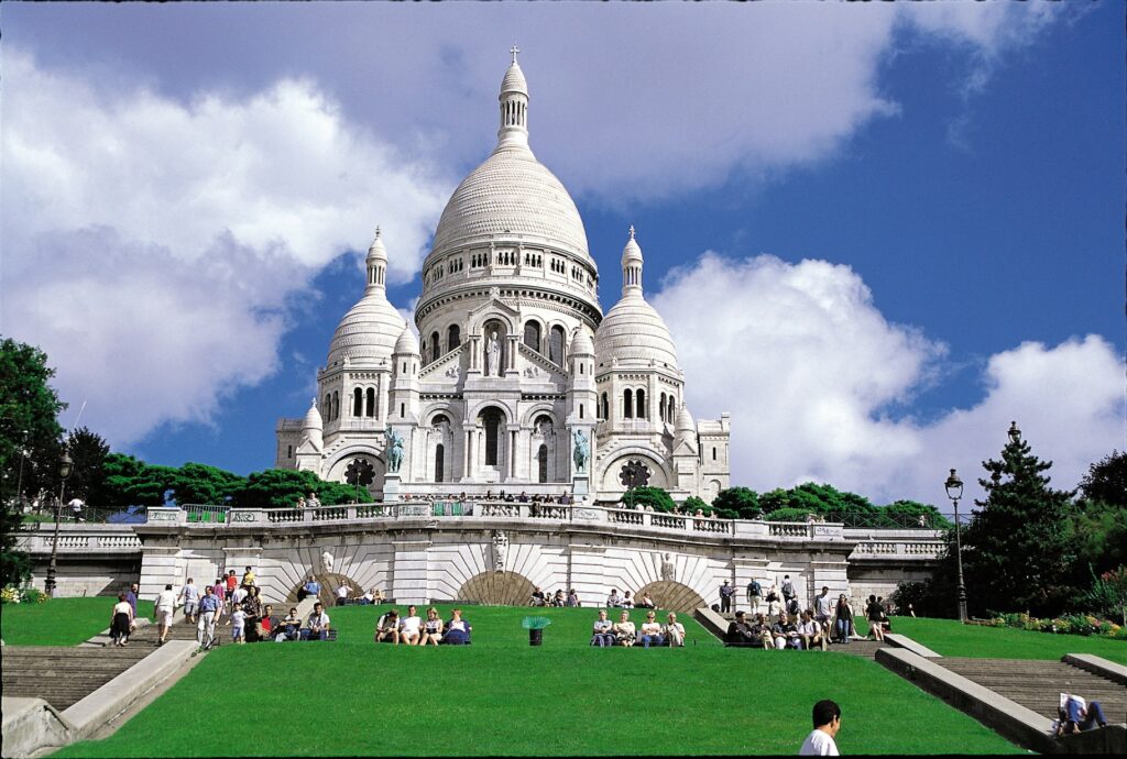 Des touristes admirent la vue sur Paris depuis le parvis de Montmartre.