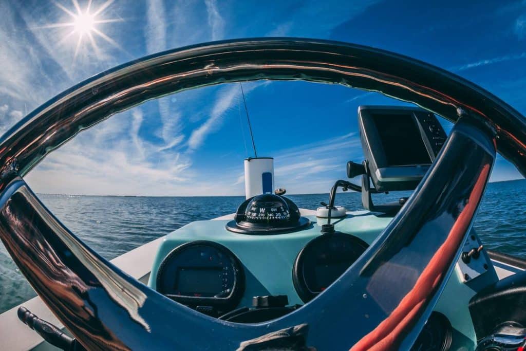 Poste de navigation d'un voilier avec barre, GPS, traceur et boussole.