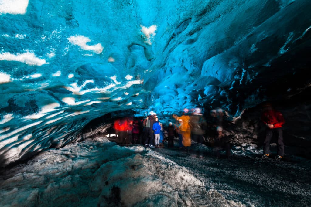 Des personnes explorent une grotte de glace en hiver à Jokulsarlon.